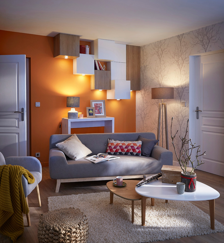 Modelo de salón abierto contemporáneo de tamaño medio sin chimenea y televisor con parades naranjas y suelo de madera clara