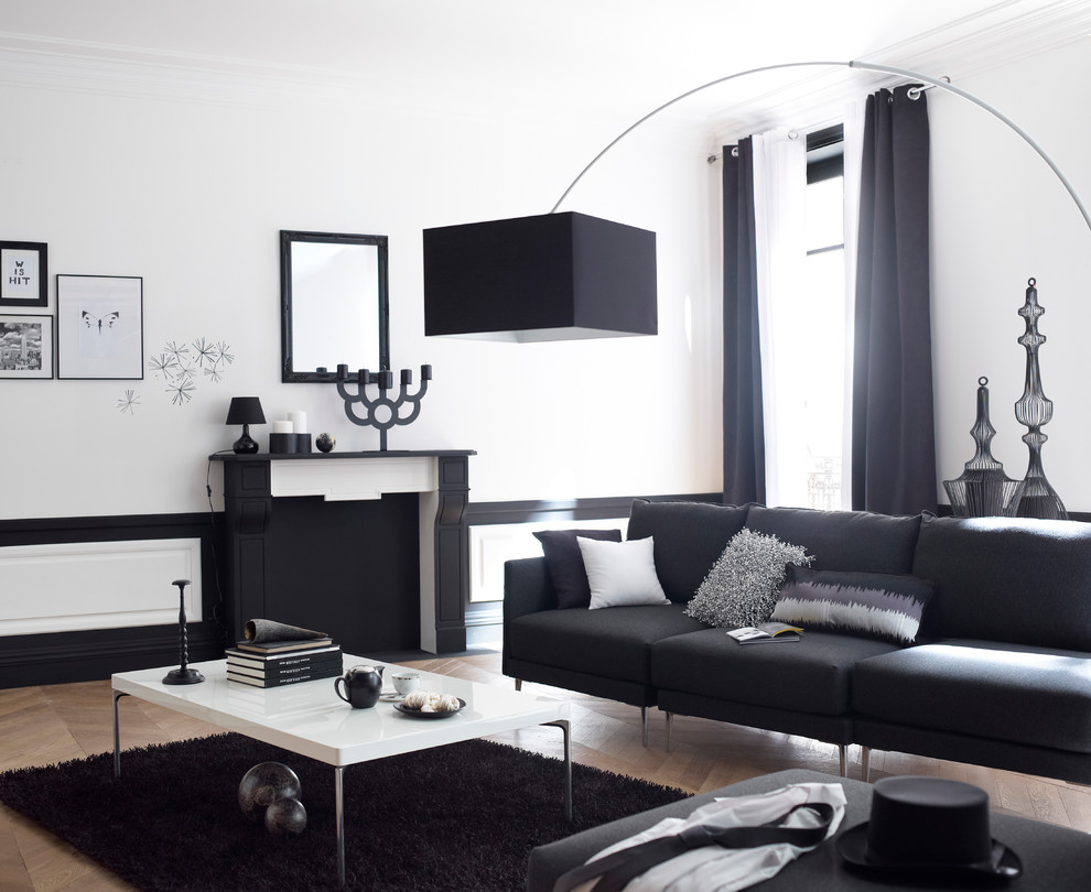 リールにあるお手頃価格の中くらいなコンテンポラリースタイルのおしゃれなLDK (白い壁、標準型暖炉、テレビなし、無垢フローリング、黒いソファ) の写真