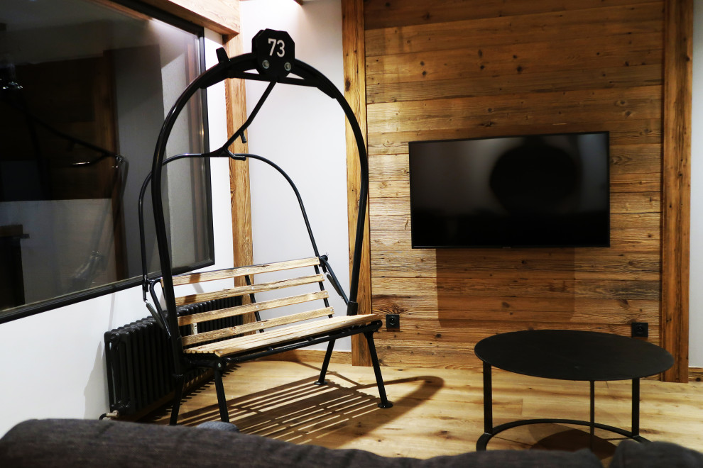グルノーブルにある中くらいなラスティックスタイルのおしゃれなLDK (茶色い壁、淡色無垢フローリング、壁掛け型テレビ、ベージュの床) の写真