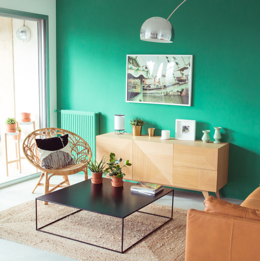 Ispirazione per un soggiorno design di medie dimensioni e aperto con pareti verdi, pavimento in cemento, nessun camino, nessuna TV e pavimento grigio