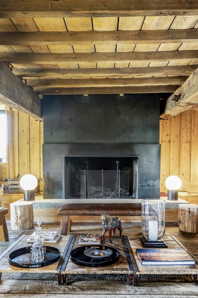 Inspiration for a large industrial enclosed medium tone wood floor living room remodel in Lyon with a standard fireplace, a metal fireplace, brown walls and no tv