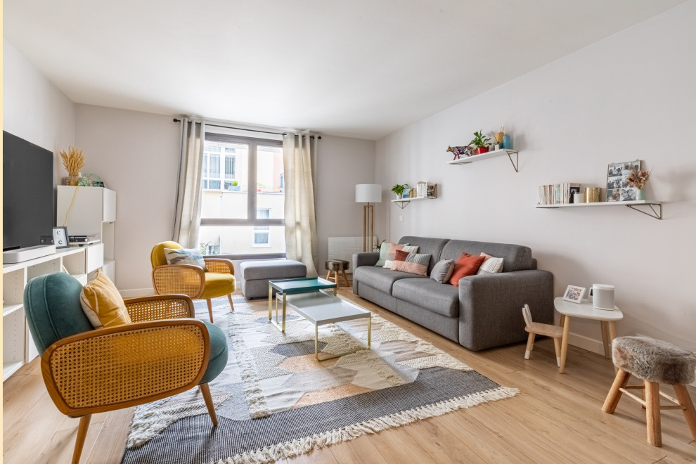 Photo of a medium sized scandi open plan living room in Paris with grey walls, brown floors, light hardwood flooring, no fireplace and a freestanding tv.