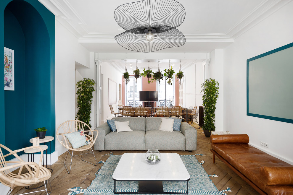 Danish open concept light wood floor and beige floor living room photo in Paris with blue walls