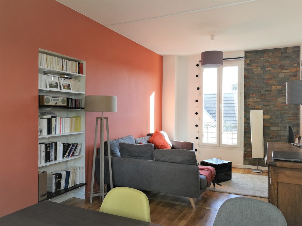 Exempel på ett litet modernt separat vardagsrum, med orange väggar, mellanmörkt trägolv, en fristående TV och brunt golv