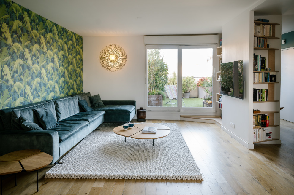 Cette photo montre un salon tendance ouvert avec un mur blanc, un sol en bois brun, aucune cheminée, un téléviseur fixé au mur, un sol marron et du papier peint.