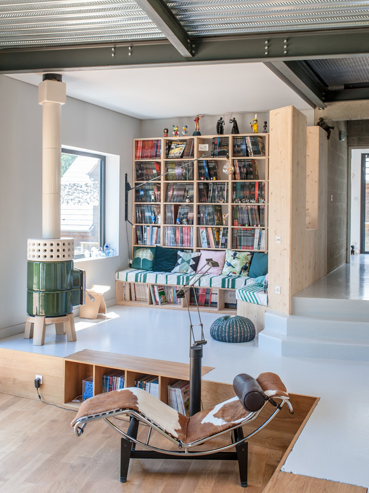 Offenes Industrial Wohnzimmer mit weißer Wandfarbe, Kaminofen und weißem Boden in Montpellier
