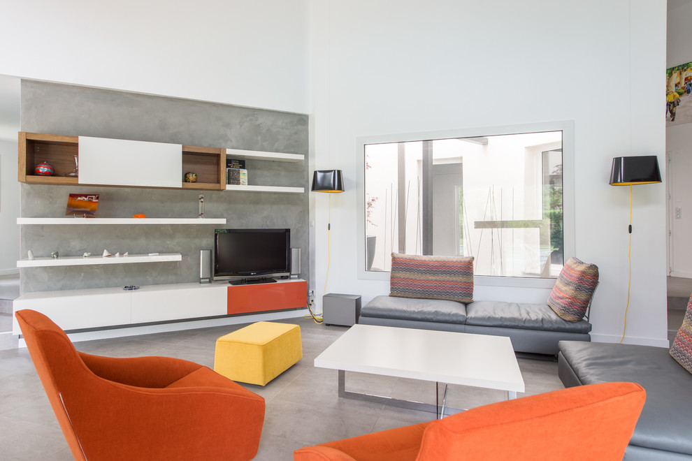 Idee per un soggiorno minimal con pareti grigie, nessun camino, TV autoportante e pavimento grigio