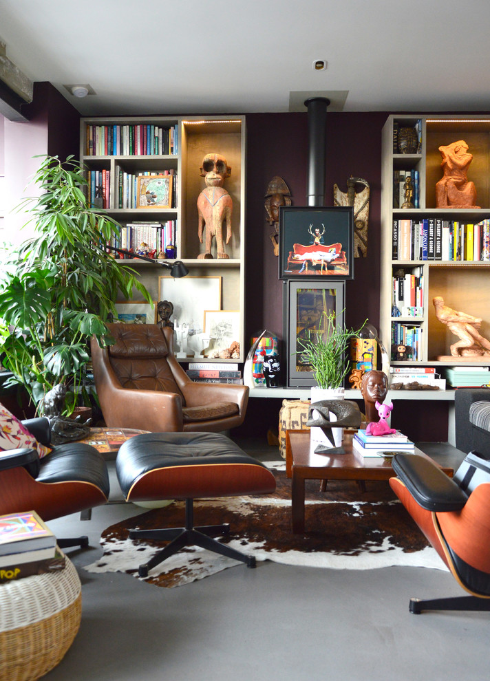 Mittelgroße, Fernseherlose, Offene Eklektische Bibliothek mit brauner Wandfarbe, Betonboden, Kaminofen und Kaminumrandung aus Metall in Paris