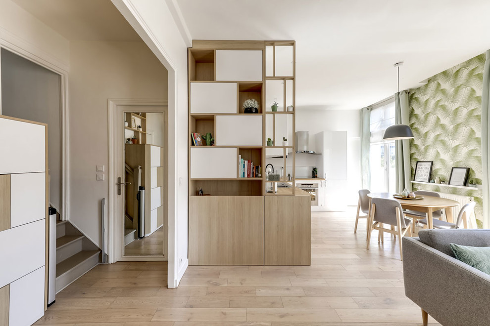 Mittelgroßes, Repräsentatives, Offenes Skandinavisches Wohnzimmer ohne Kamin mit weißer Wandfarbe, hellem Holzboden und TV-Wand in Paris