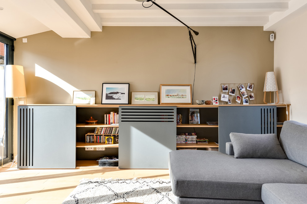 Idee per un soggiorno minimal aperto con libreria, pareti beige, parquet chiaro, nessuna TV e pavimento beige