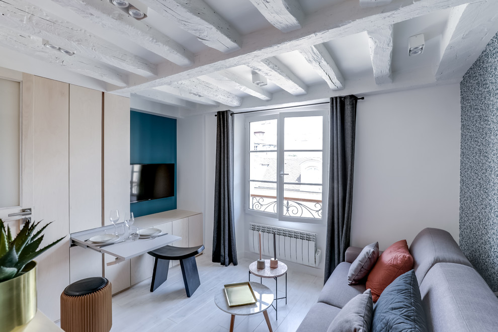 Idee per un piccolo soggiorno nordico con pareti blu, pavimento in legno verniciato, nessun camino, TV a parete e pavimento bianco