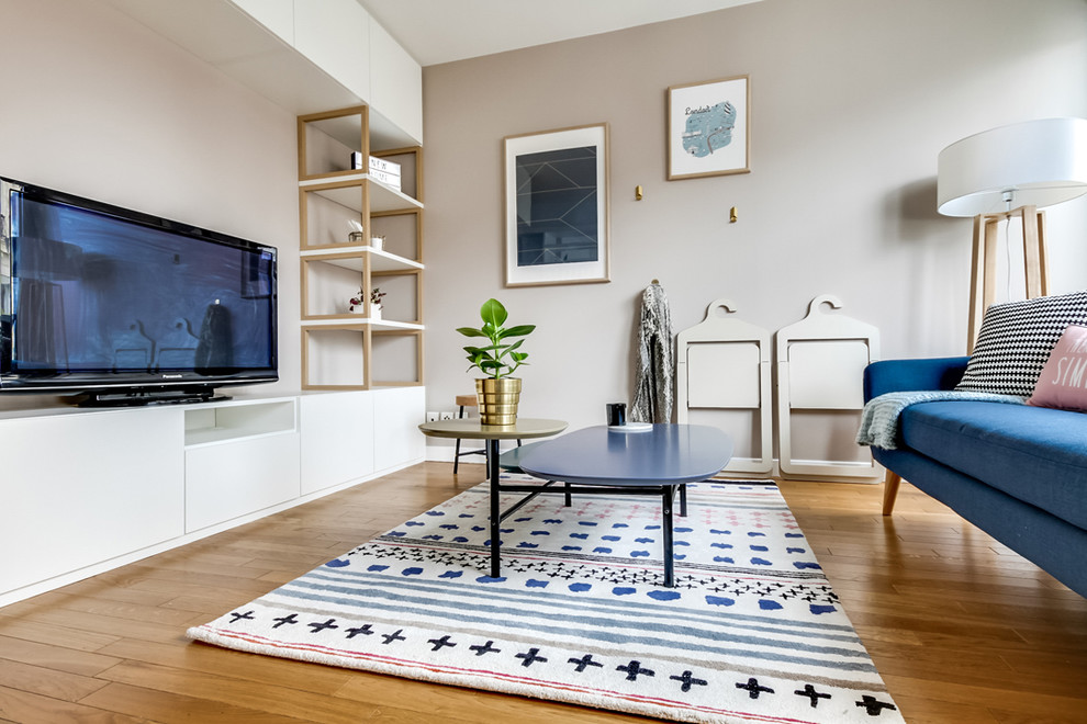 Small scandi open plan living room in Paris with beige walls, light hardwood flooring and a freestanding tv.