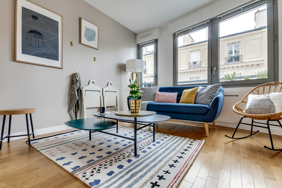 Réalisation d'un petit salon nordique ouvert avec un mur beige et parquet clair.