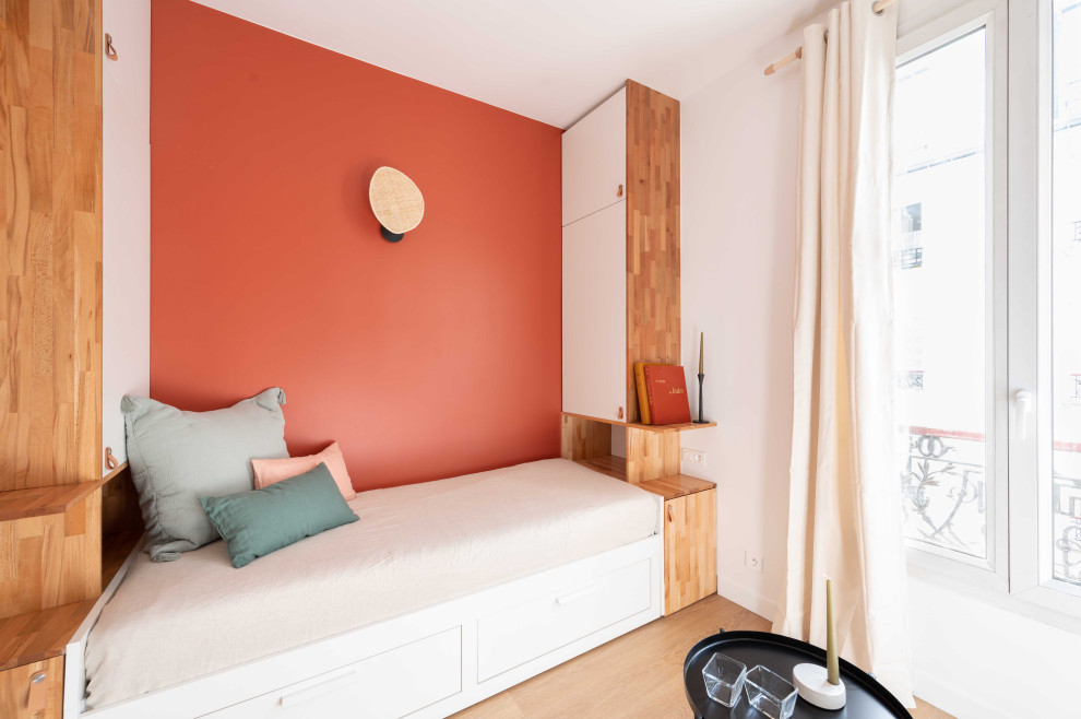 Пример оригинального дизайна: маленькая изолированная гостиная комната в современном стиле с с книжными шкафами и полками, красными стенами, светлым паркетным полом и телевизором на стене без камина для на участке и в саду