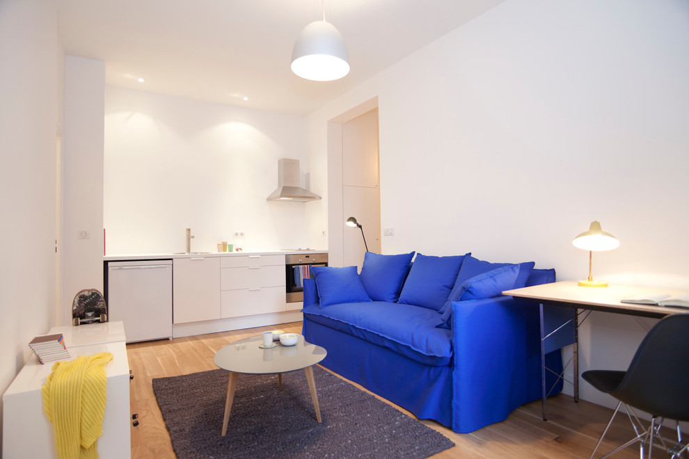 Kleines, Offenes, Fernseherloses Modernes Wohnzimmer ohne Kamin mit weißer Wandfarbe, hellem Holzboden und braunem Boden in Paris