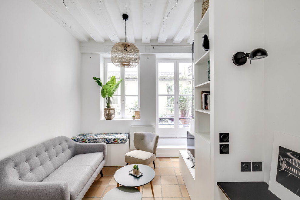 Modelo de salón para visitas cerrado nórdico con paredes blancas, suelo de baldosas de terracota, televisor independiente y suelo beige