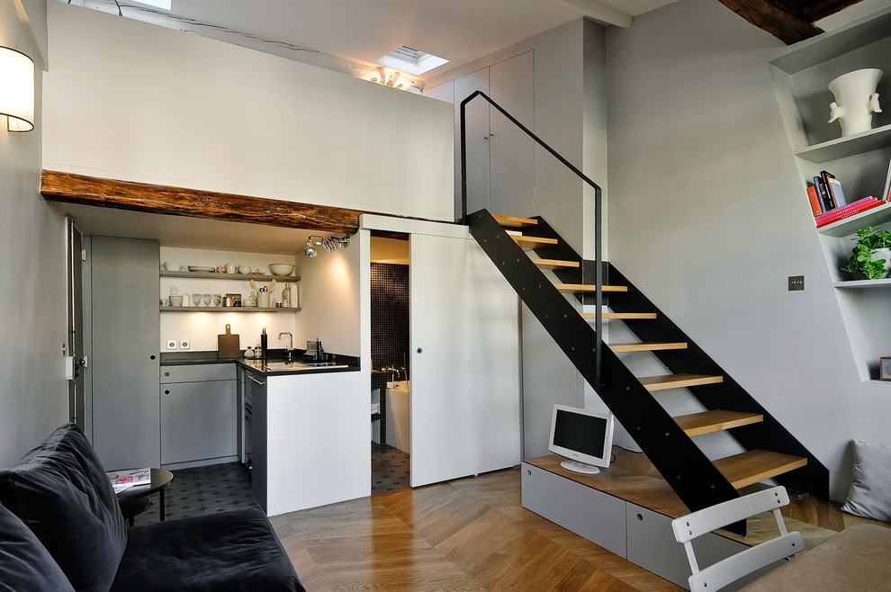 Esempio di un soggiorno design di medie dimensioni e aperto con pareti bianche, pavimento in legno massello medio, TV autoportante e pavimento marrone