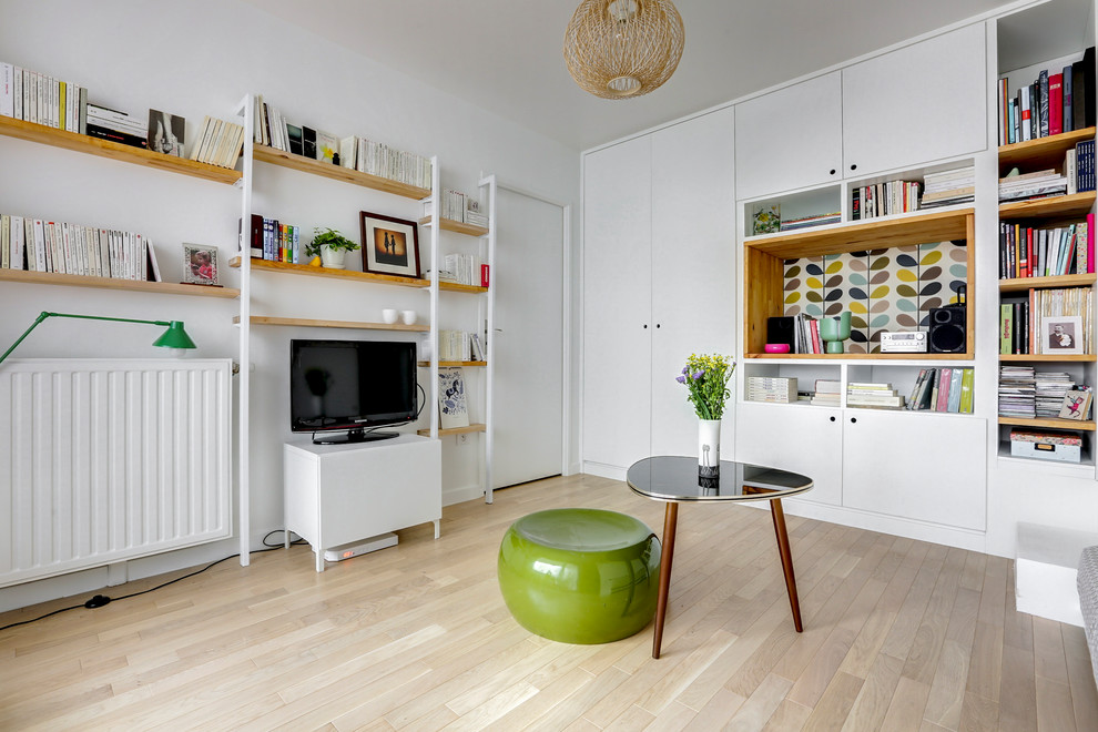 Abgetrenntes Nordisches Wohnzimmer mit weißer Wandfarbe, hellem Holzboden, freistehendem TV und beigem Boden in Paris