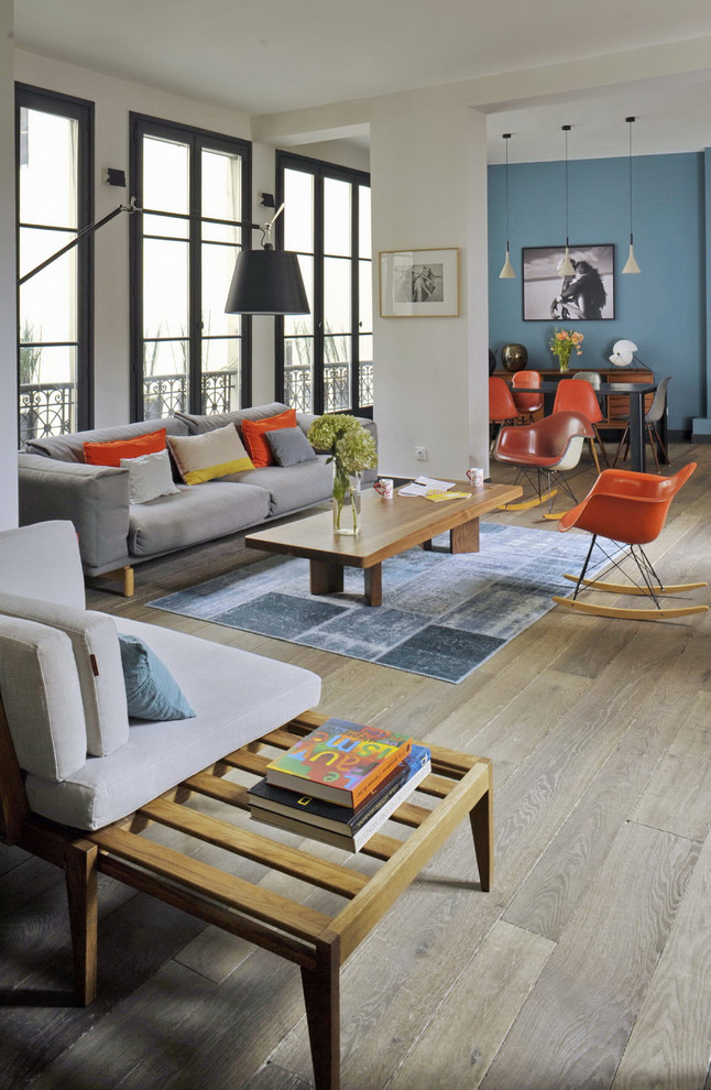 Photo of an eclectic living room in Paris with white walls and light hardwood flooring.