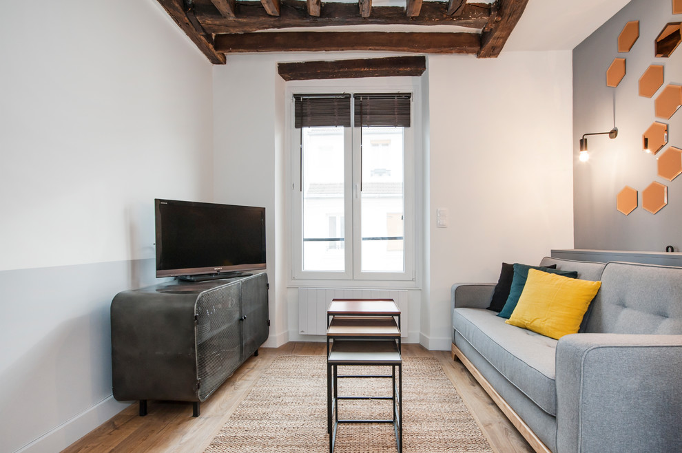 Mittelgroßes, Offenes Modernes Wohnzimmer mit weißer Wandfarbe, braunem Holzboden und freistehendem TV in Paris