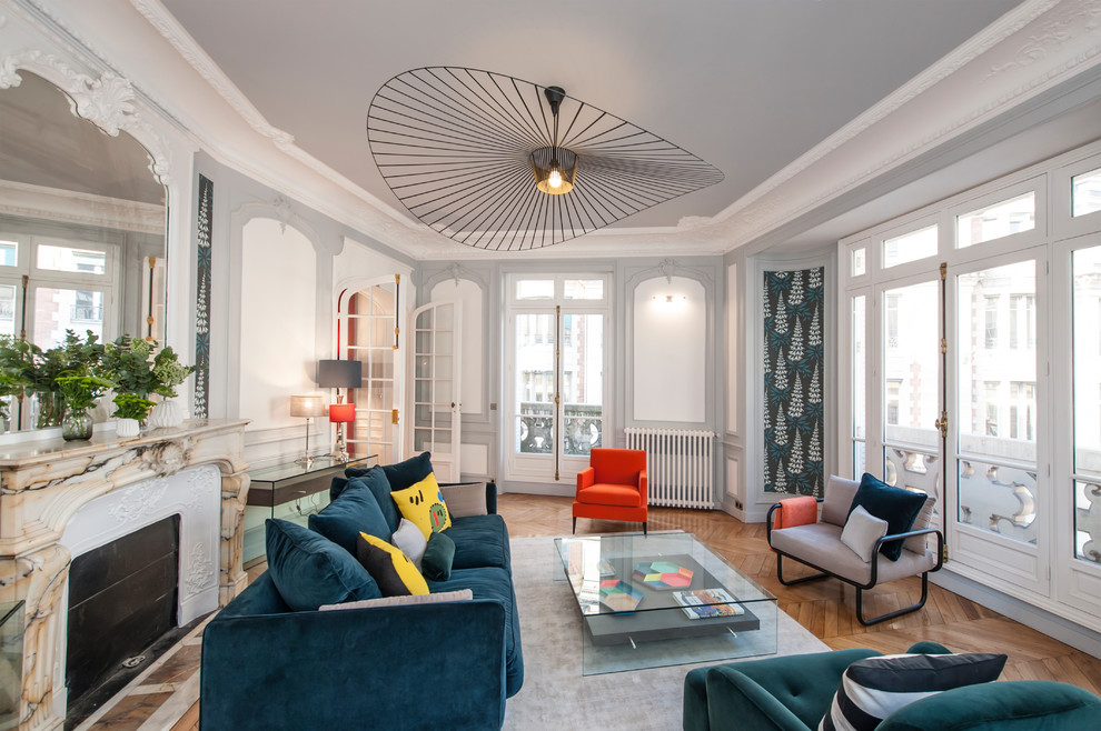 Repräsentatives, Abgetrenntes, Großes Modernes Wohnzimmer mit bunten Wänden, braunem Holzboden und Kamin in Paris
