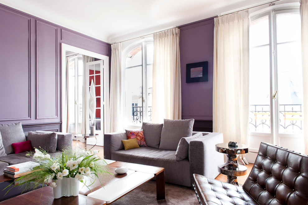 パリにあるお手頃価格の広いトランジショナルスタイルのおしゃれなリビング (紫の壁、無垢フローリング、標準型暖炉、テレビなし) の写真
