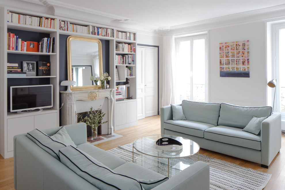 Repräsentatives, Abgetrenntes Klassisches Wohnzimmer mit weißer Wandfarbe, hellem Holzboden, Kamin, Kaminumrandung aus Stein und braunem Boden in Paris