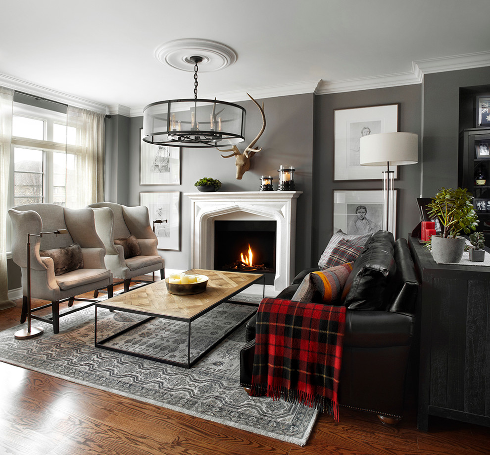 Inspiration pour un salon traditionnel de taille moyenne avec un mur gris, un sol en bois brun, une cheminée standard et un manteau de cheminée en béton.