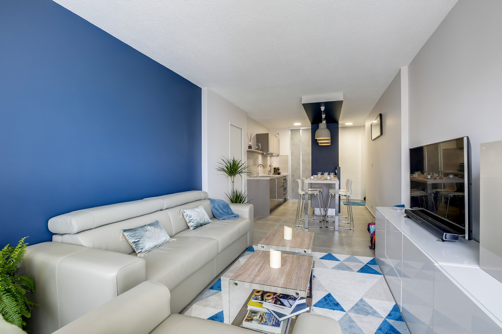 Inspiration för ett mellanstort funkis allrum med öppen planlösning, med blå väggar, klinkergolv i keramik, en fristående TV och beiget golv