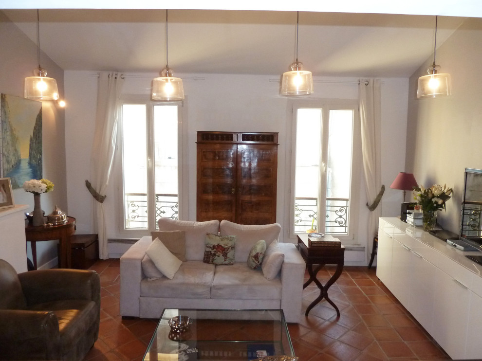Mediterranes Wohnzimmer mit weißer Wandfarbe, Terrakottaboden und orangem Boden in Sonstige