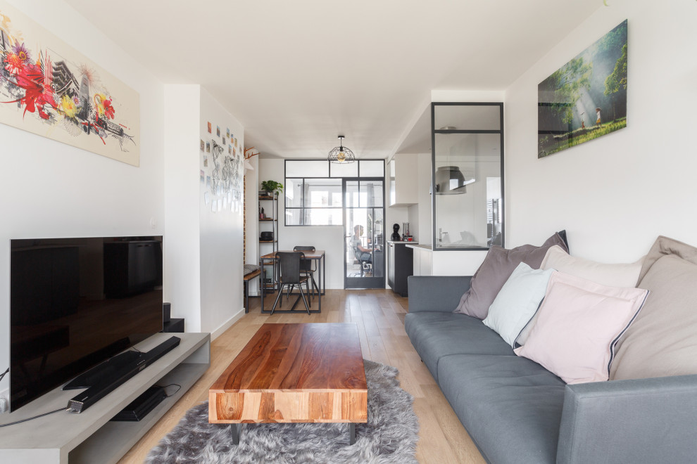 Diseño de salón abierto urbano de tamaño medio sin chimenea con paredes blancas, suelo de madera clara, televisor independiente y suelo beige