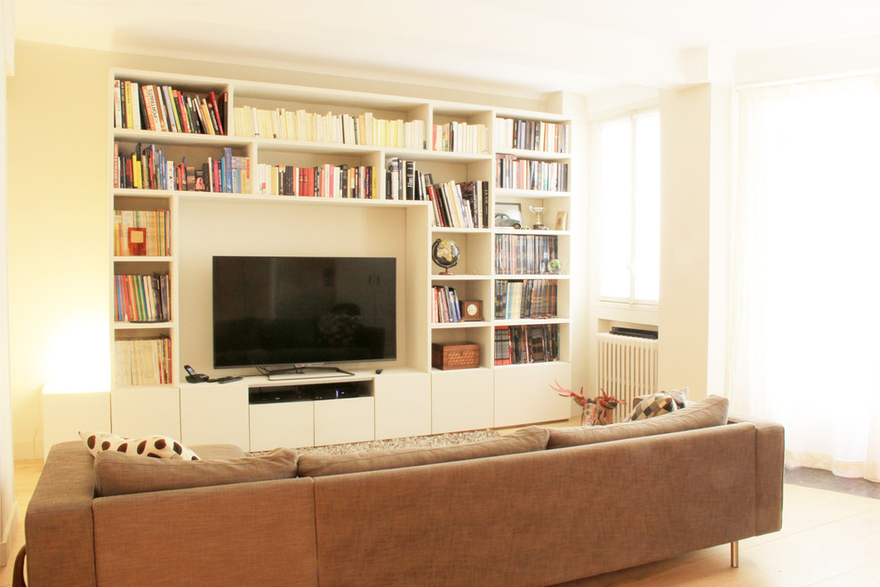 Aménagement d'un grand salon contemporain ouvert avec une bibliothèque ou un coin lecture, un mur blanc, parquet clair, aucune cheminée, un téléviseur encastré et un sol beige.