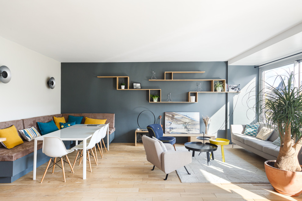Großes, Offenes Modernes Wohnzimmer ohne Kamin mit grauer Wandfarbe, hellem Holzboden, freistehendem TV und beigem Boden in Paris