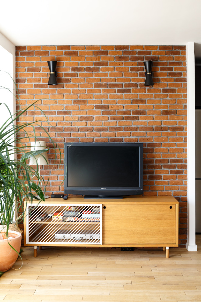 Ejemplo de salón abierto minimalista grande sin chimenea con paredes grises, suelo de madera clara, televisor independiente y suelo beige