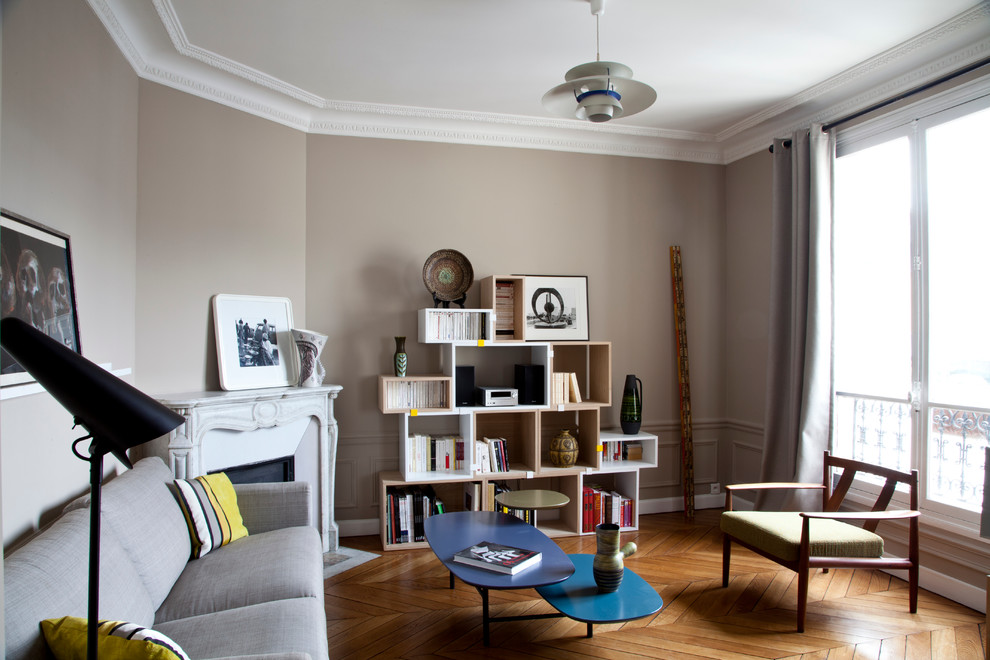 Mittelgroße, Fernseherlose, Abgetrennte Moderne Bibliothek mit beiger Wandfarbe, braunem Holzboden, Eckkamin und Kaminumrandung aus Stein in Paris