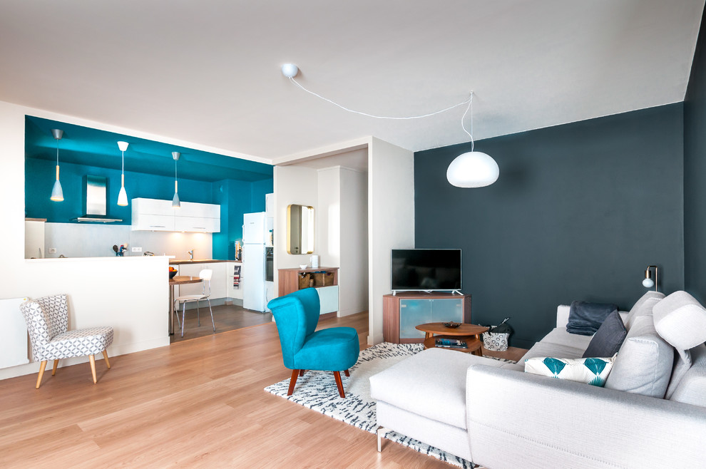 Cette photo montre un salon tendance de taille moyenne avec un mur bleu et sol en stratifié.