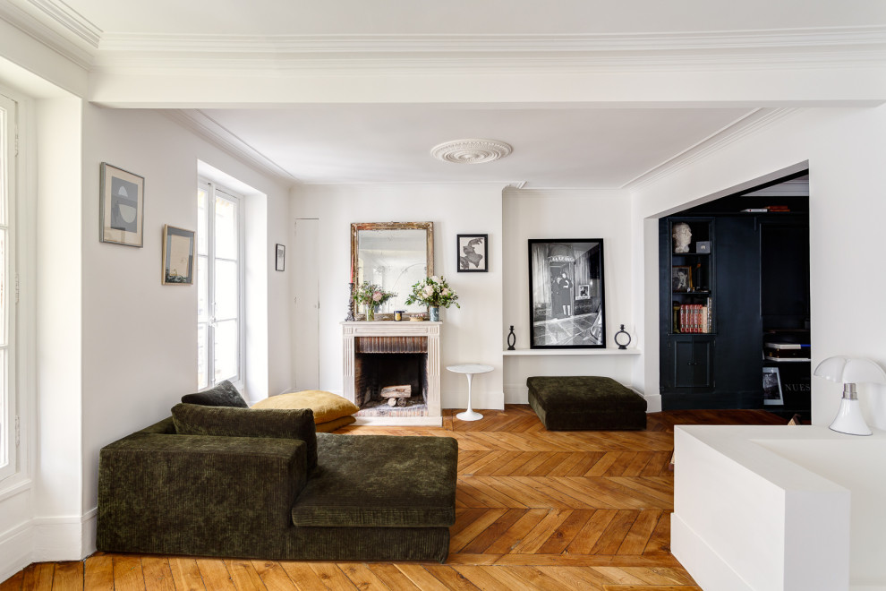 Cette photo montre un salon chic de taille moyenne et ouvert avec un mur blanc, un sol en bois brun, une cheminée standard, un manteau de cheminée en pierre, aucun téléviseur et un sol marron.