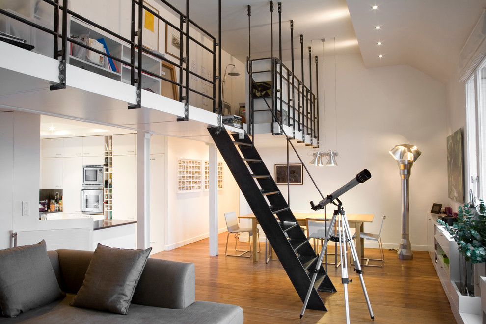 Mittelgroßes, Fernseherloses Modernes Wohnzimmer ohne Kamin mit weißer Wandfarbe und braunem Holzboden in Paris