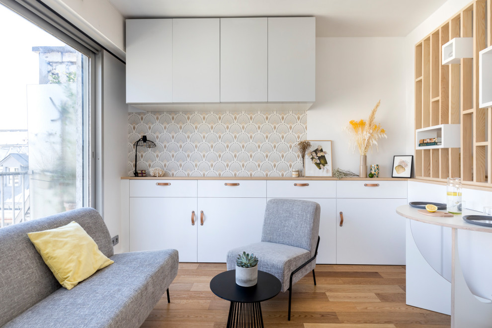 Immagine di un piccolo soggiorno design aperto con pareti bianche e pavimento in compensato