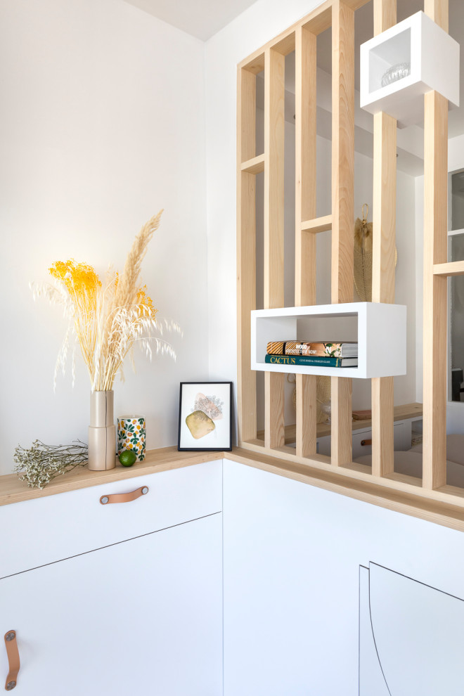 Kleines, Offenes Wohnzimmer mit weißer Wandfarbe und Sperrholzboden in Paris