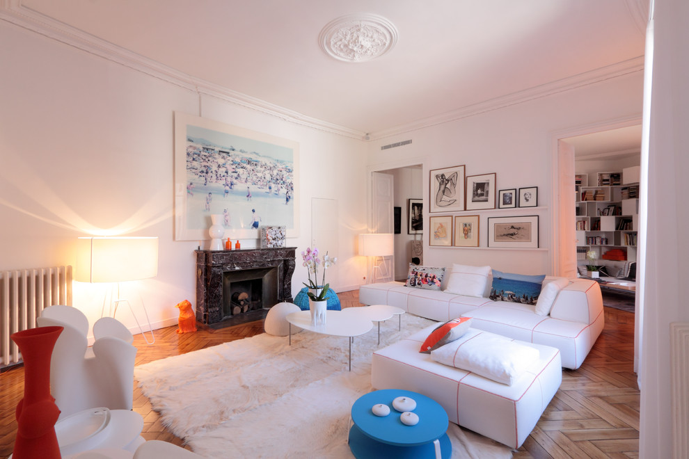 Cette photo montre un salon tendance de taille moyenne et ouvert avec un mur blanc, parquet clair, une cheminée standard et éclairage.