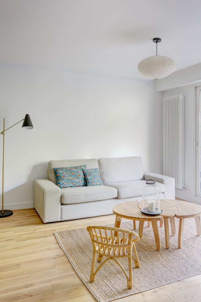 Ispirazione per un soggiorno nordico di medie dimensioni e aperto con pareti bianche, parquet chiaro, TV autoportante e pavimento beige