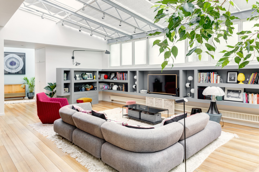 Example of a large eclectic open concept light wood floor and beige floor living room design in Paris with multicolored walls, no fireplace and a media wall