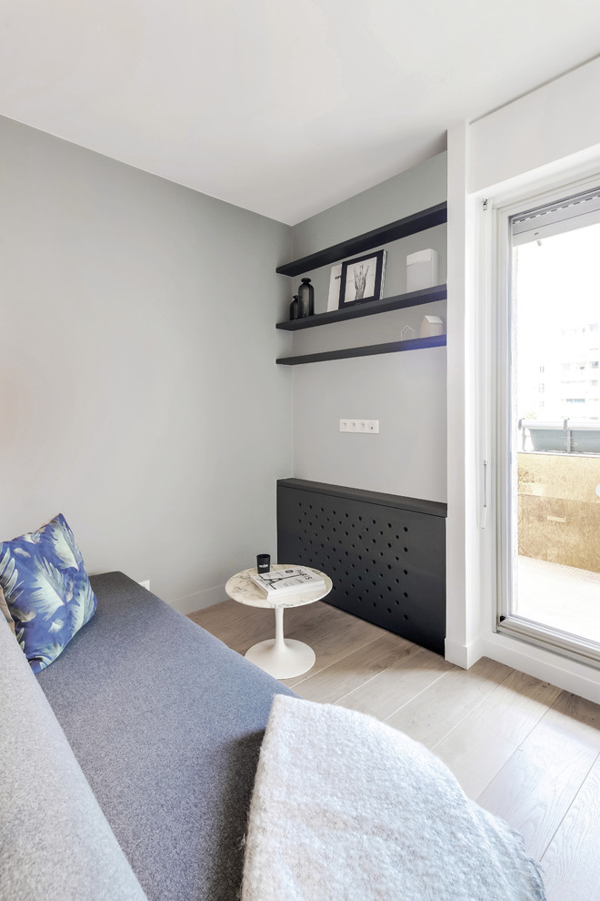 Foto di un soggiorno minimalista di medie dimensioni e aperto con pareti grigie, pavimento in legno massello medio, nessun camino, TV a parete e pavimento marrone