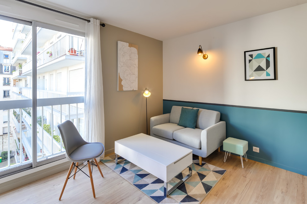 Kleines, Offenes Skandinavisches Wohnzimmer mit beiger Wandfarbe, Laminat und freistehendem TV in Paris