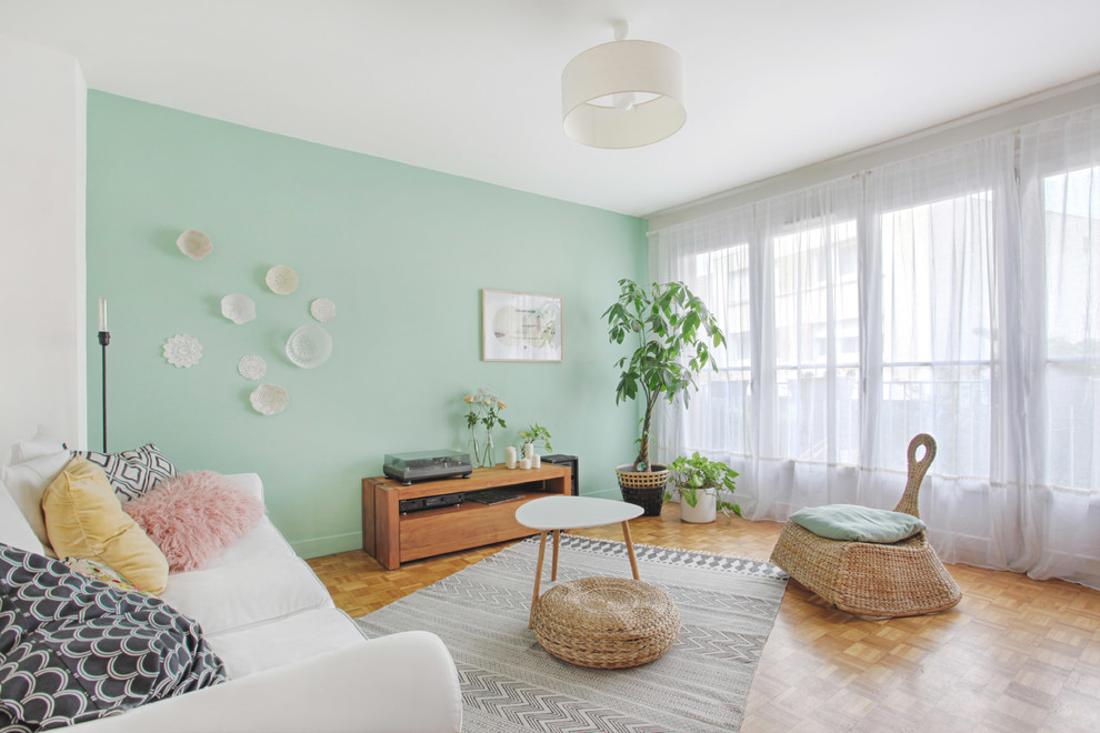 Immagine di un soggiorno scandinavo di medie dimensioni e aperto con pareti verdi e parquet chiaro