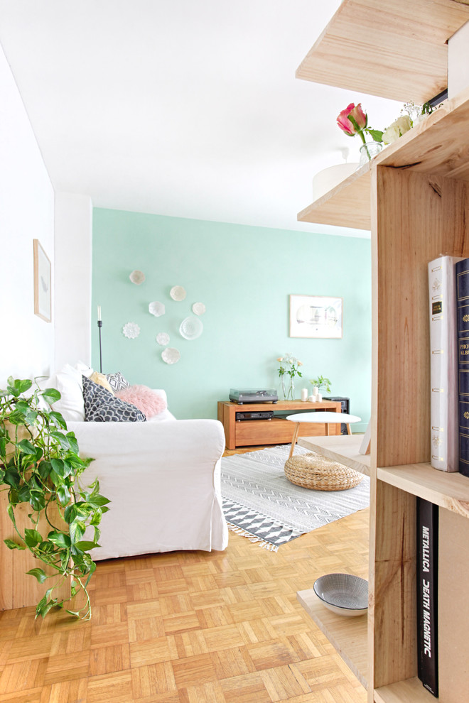 Medium sized scandi open plan living room in Paris with green walls and light hardwood flooring.