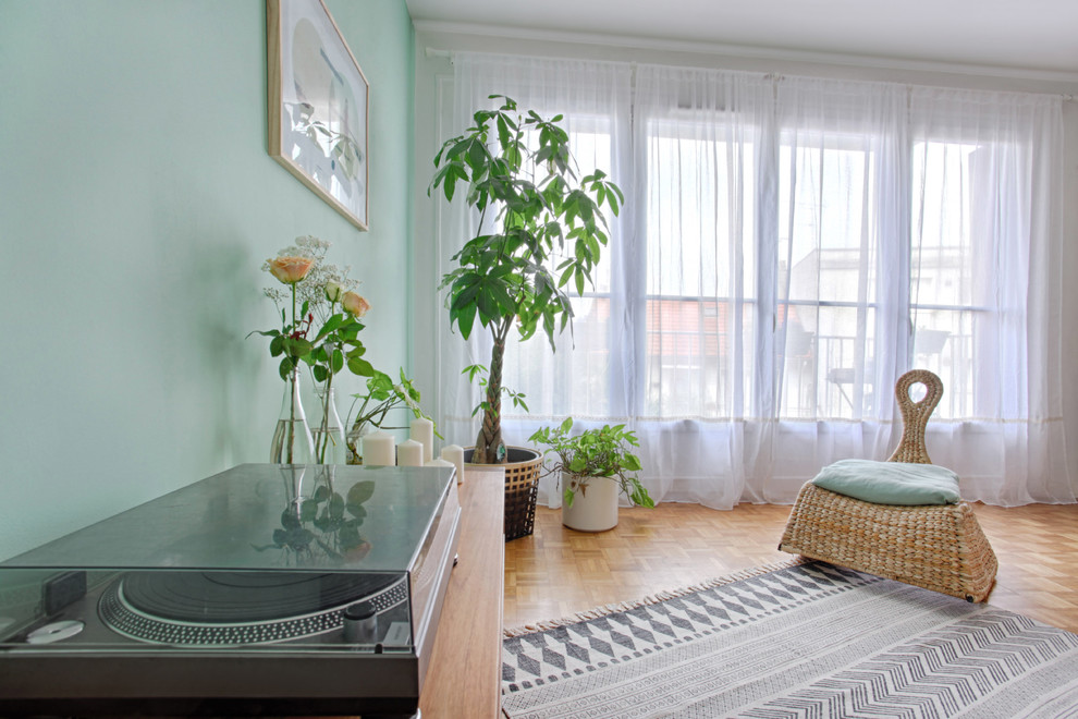 Immagine di un soggiorno nordico di medie dimensioni e aperto con pareti verdi e parquet chiaro