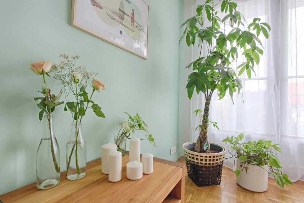 Foto på ett mellanstort minimalistiskt allrum med öppen planlösning, med gröna väggar och ljust trägolv