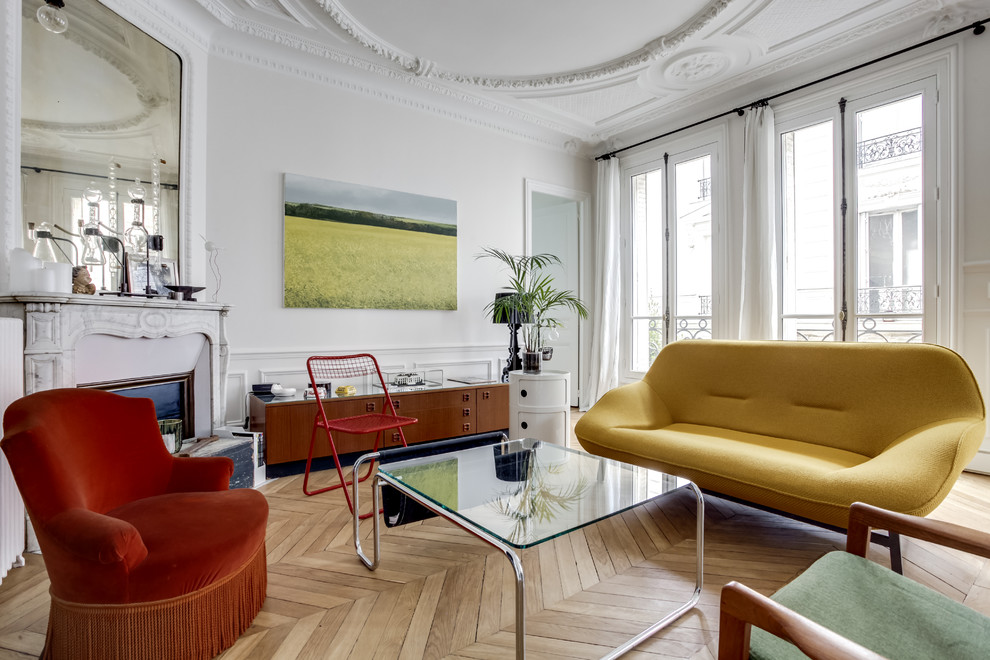 This is an example of a medium sized traditional open plan living room in Paris with white walls, light hardwood flooring, a corner fireplace and a freestanding tv.
